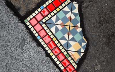 Un artista francese gira per le città riparando le buche con dei mosaici colorati